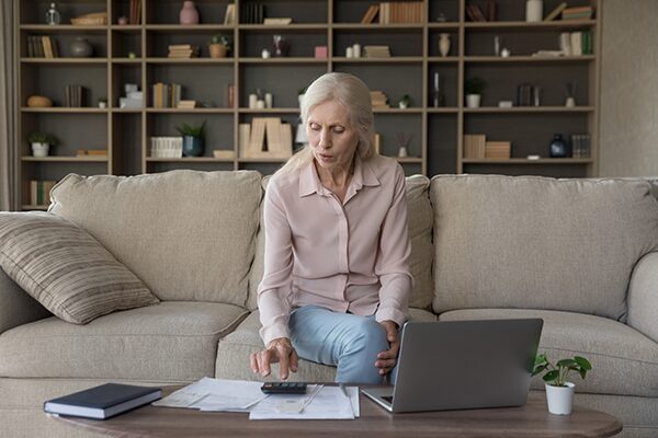 Une personne âgée qui calcule ses revenus avec l'ASPA dans son salon