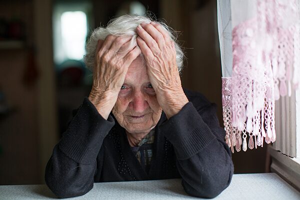 Une femme âgée souffrant d'atrophie hippocampique qui se tient la tête entre les mains
